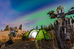Photo by Helmut Koch (Germany) of their trusted travel companions in Yukon Territory, Canada, enjoying the breathtaking, vivid green northern lights in the sky above. RTW tour, 2016. Honda Transalps (1989 and 1993).