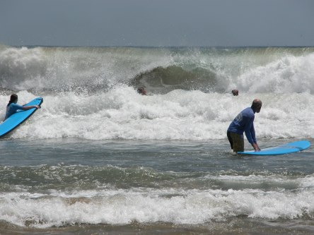 Father and daughter heading out to catch waves.