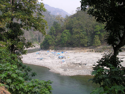 Locals hand crushing river rocks for roadways in a lovely setting