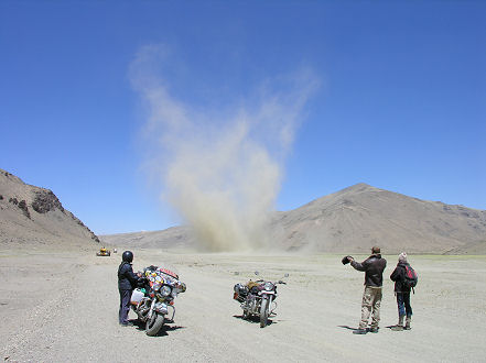 Wind whips up dust on the sandy section of road