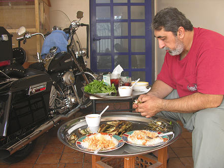 Enjoying a fresh fried fish barbecue in Abu Ali's garage