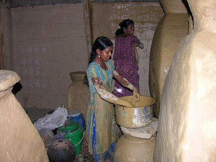 Women, mud plastering the house's inside walls and floors