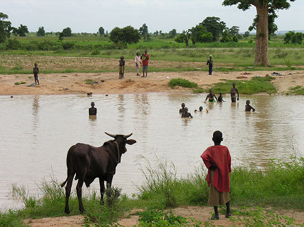 Children cool off in a wet season pond