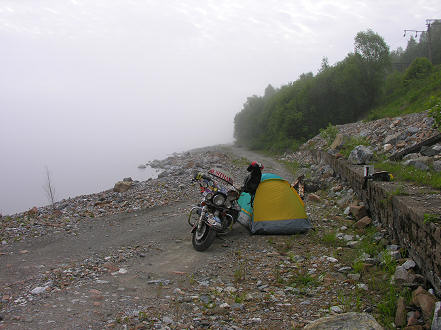 A rocky camp next to foggy Lake Baikal located after bike repairs in the dark