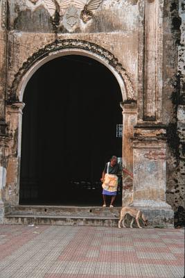 Woman chases a dog away from a church in Nicaragua.