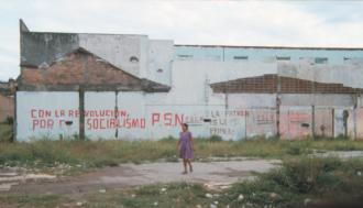 Woman walks in front of propaganda signs, Nicaragua.