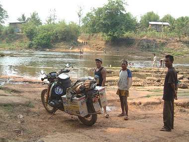 Jurgen's bike at riverside with locals looking on