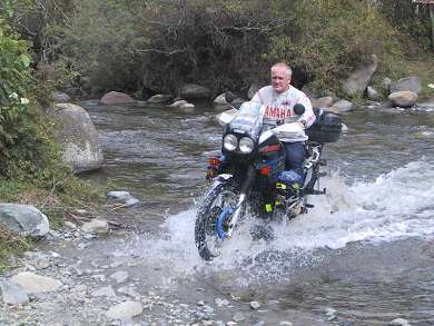 Patrick riding through river in Vilcabamba in Ecuador.