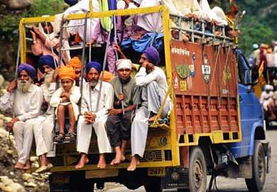 I passed these sikhs several times. 2 trucks: each truck had about 40 people in it. Also shook the right man's hand as I overtook them. The truck and my bike were both moving (them at 8 mph, me at 8.1 mph)!
