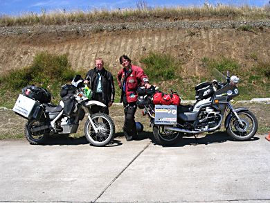 David Mclure Taylor and I trade stories on the side of the road in Chile. Mine did not involve pinning myself under my bike or having a cop crash it for me.