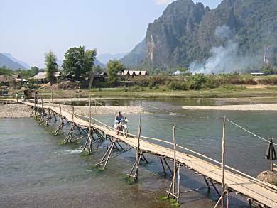 Pat on bike on bamboo bridge at Vang Vieng, Laos.