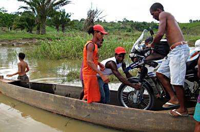 Loading El Viento into Chefe's rickity wooden canoe.