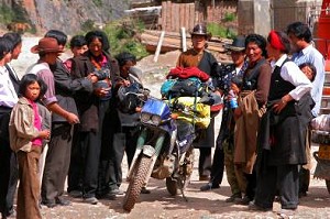 by Carl Parker, China; Always curious Tibetans check out the bike and gear, small village in NE Tibet, Honda AX-1.