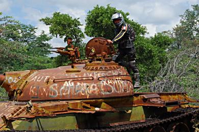 Abandoned tanks and other military equipment are left to waste away on the side of the road in Angola.