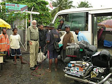 Air for the rear tyre at a roadside stop, Lae.