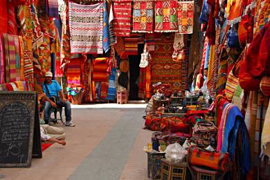 Colorful carpets are displayed in the medina within the walled town of Essaouira.