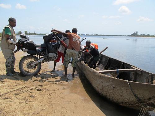 Tiffany Coates putting bike in canoe, Madagascar.