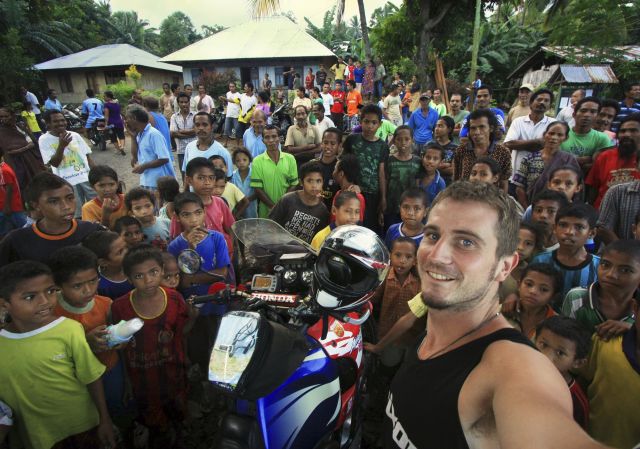 June: by George Guille, Sark, Channel Islands. Drawing a crowd on Flores, Indonesia - 'You are the first Westerner to stay in our village for 40 years!' Riding RTW; Honda XRV750 Africa Twin.