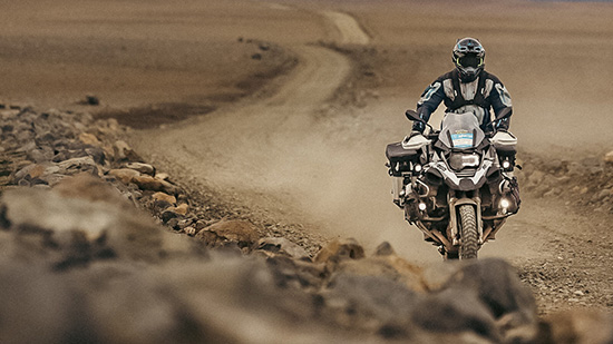 Martin Litschauer rides along a dusty, rocky road.