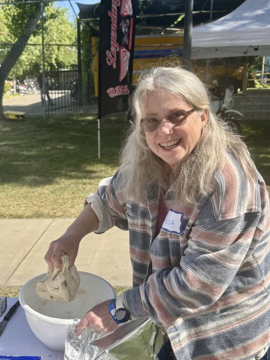 Linda Rodda preparing bread dough at camp.