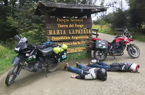 Elle and Jeremy resting face down in front of Tierra del Fuego sign