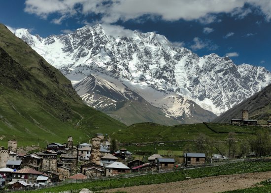 Werner Zwick, Georgian village in forefront with snowy mountains in background.