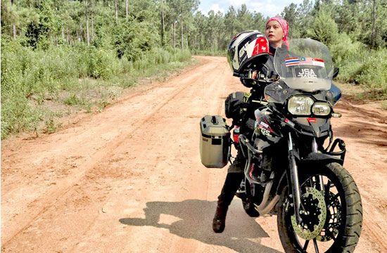 Anita Yusof and bike on a dirt road