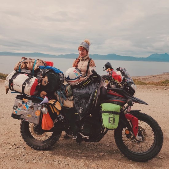 Lala Barlow with her motorcycle, fully loaded for adventure.
