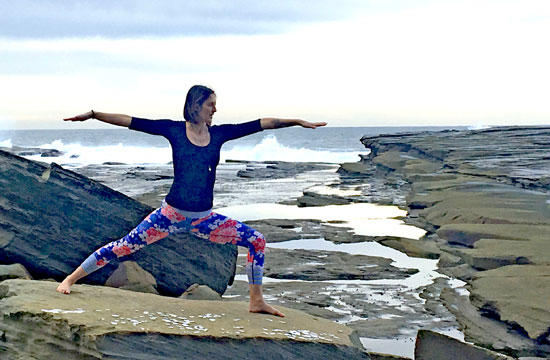 Sarah's yoga pose on beach rock