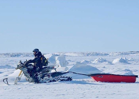 Oliver Solaro pulling a snow sled with Gertrude, the snow bike.