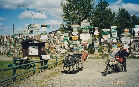 Simon at the travellers signpost, where people put up signs for other travellers