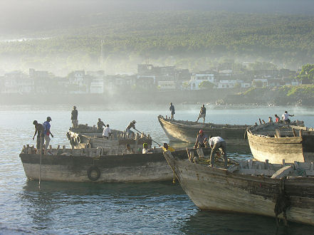 Sunrise as the wooden boats go out to collect imported bags of rice