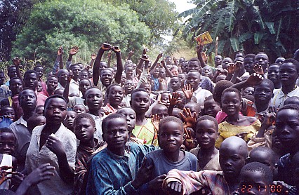 Kay, the only white face, in the middle of a group of interested school children