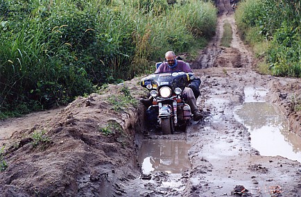 Peter Forwood riding the world's most traveled motorcycle on the muddy roads of the Congo.
