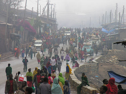 People traffic on a town street in the foggy mountains towards Harar
