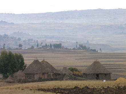 Stone and grass roofed huts dot the hillsides