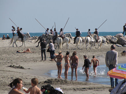 Picadors practicing on the beach amongst bathers
