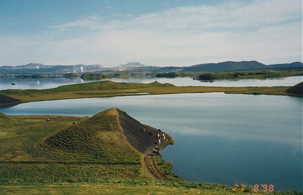 Geysers letting off steam in the background of mirror smooth lakes