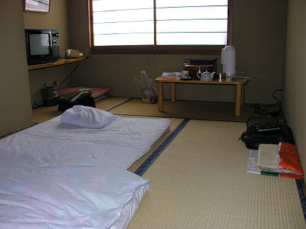 Traditional style hotel room with tatami mat flooring and futon