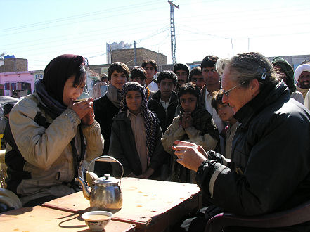 Miki and Kay being watched by locals as they drink some tea