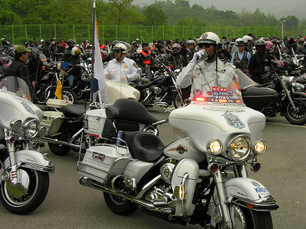 Road Captain, psuedo policeman, directs motorcycles at the DMZ