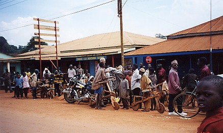 Busy street scene, wooden scooters, bicycles and walkers