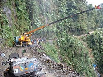 Crane working to collect the cargo from a truck that slipped off the edge days before.   See the blue tarp in the bottom right corner and the avalanche effect above it.