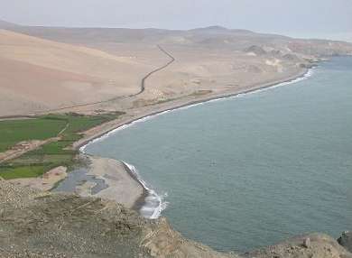Chris is taking this picture from the seat of his bike on the road. It is a long way down with no guardrail!.