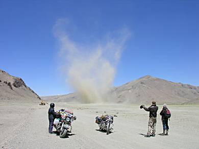 Wind whips up dust on the sandy section of road.