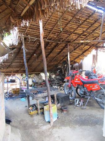 Tiffany Coates in bike repair shop in Madagascar.