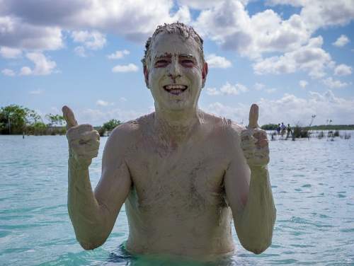 Steve Douglas exfoliating with mud in Bacalar Lagoon, Mexico.