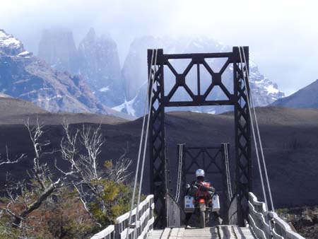 photo by Michel de Schoutheete of Gerald Regnier, Belgium, crossing a bridge in Park National Torres del Paine, Chile, Transalp, South America trip.